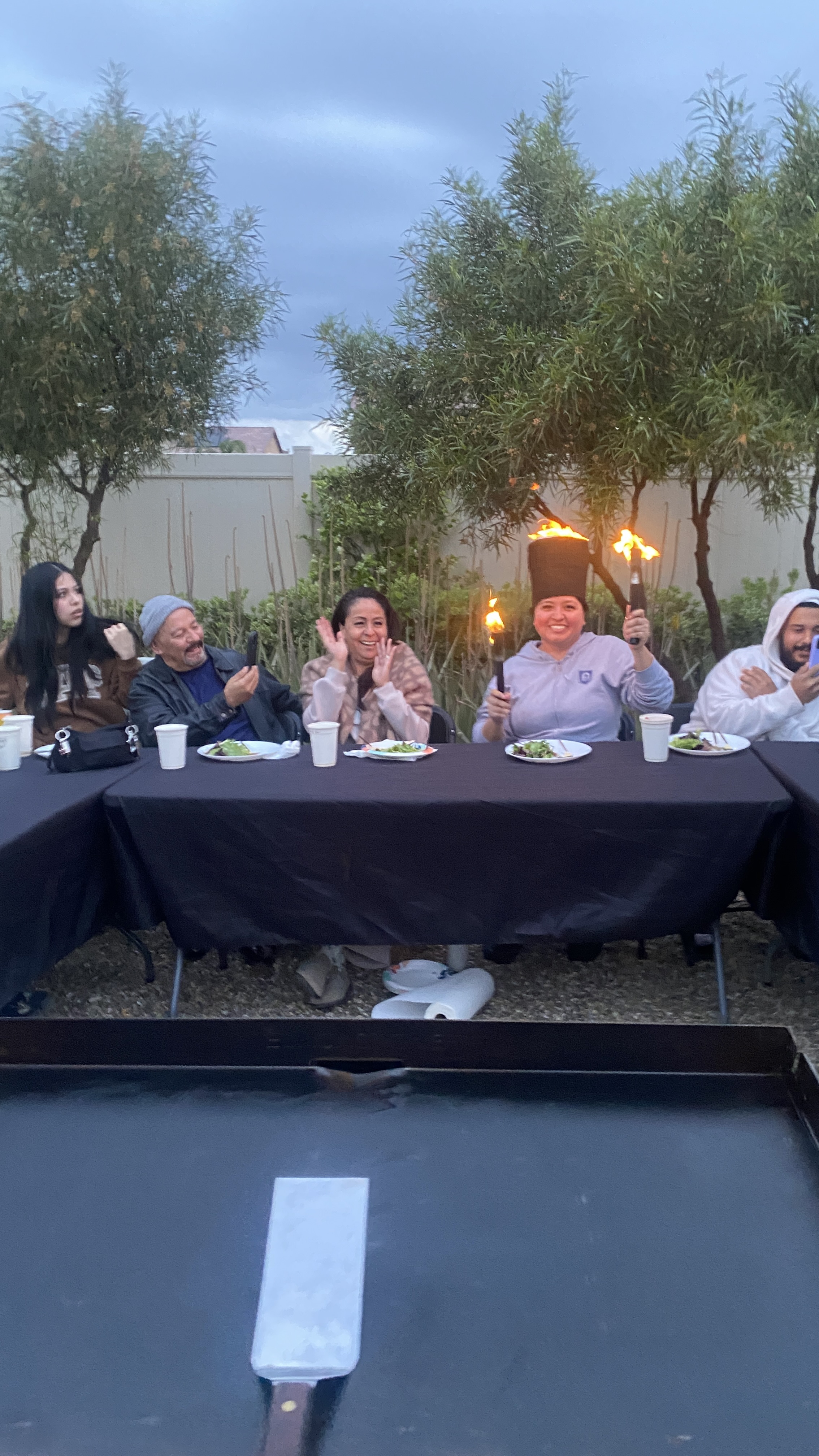 Adult guests enjoying a live hibachi fire interaction
